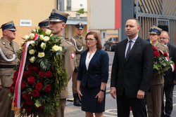 Złożenie kwiatów pod tablicą upamiętniającej internowane i więzione działaczki opozycji antykomunistycznej. Fot. Mikołaj Bujak (IPN)